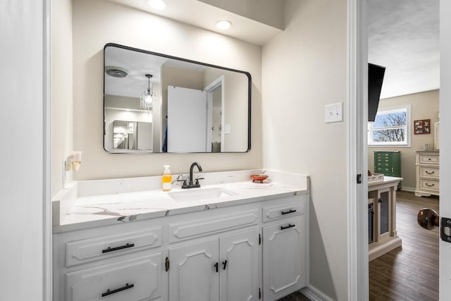 bathroom featuring wood finished floors, vanity, and baseboards