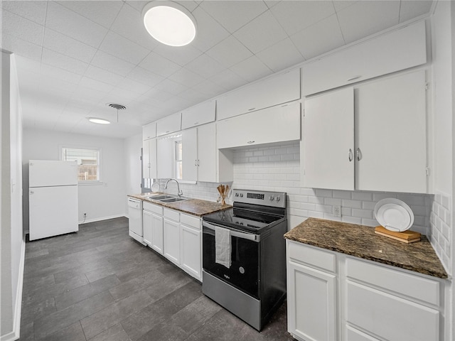 kitchen featuring white appliances, a sink, visible vents, white cabinets, and tasteful backsplash