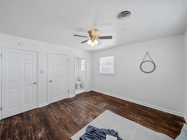 unfurnished bedroom with baseboards, visible vents, a ceiling fan, connected bathroom, and wood finished floors