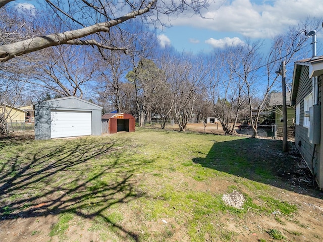 view of yard with a garage, an outdoor structure, and fence