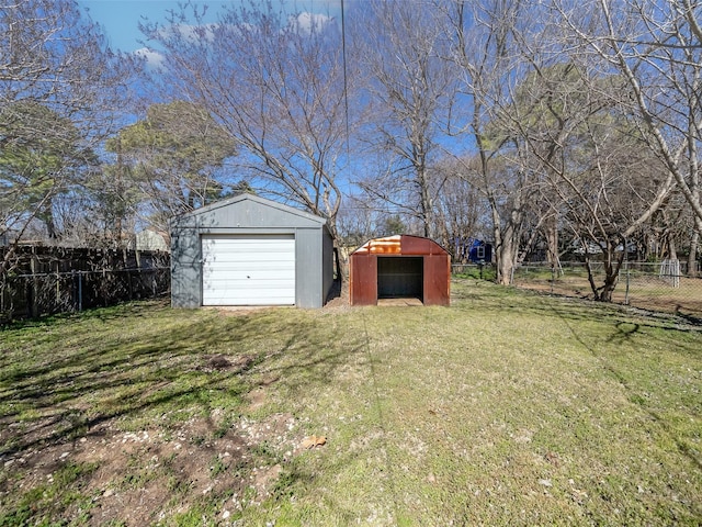 view of yard with a garage, an outdoor structure, and fence