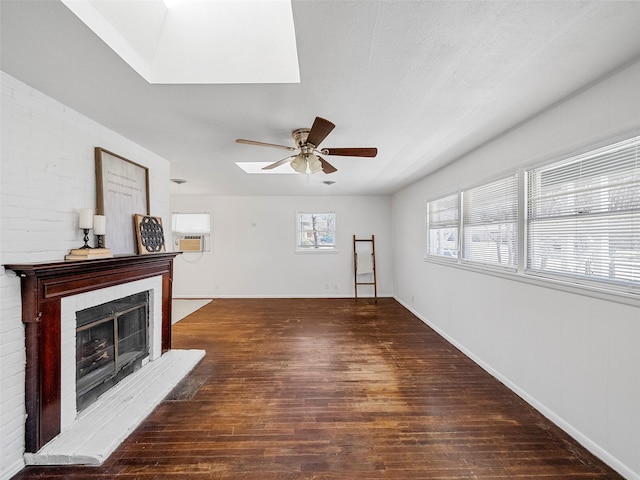 unfurnished living room featuring baseboards, a ceiling fan, a fireplace with raised hearth, and wood finished floors