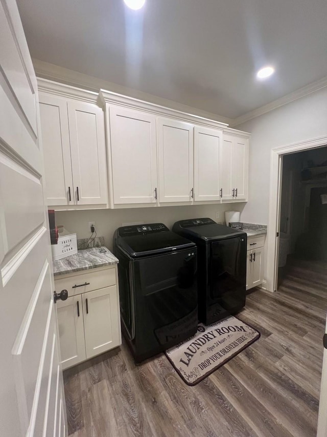 laundry room with crown molding, cabinet space, dark wood finished floors, and washing machine and clothes dryer