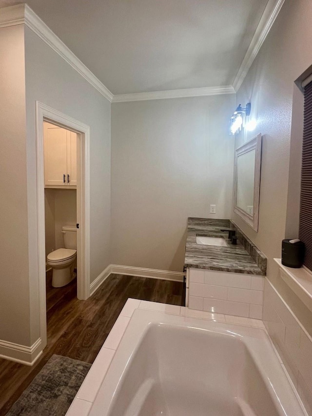 full bath with a bathtub, ornamental molding, toilet, and wood finished floors