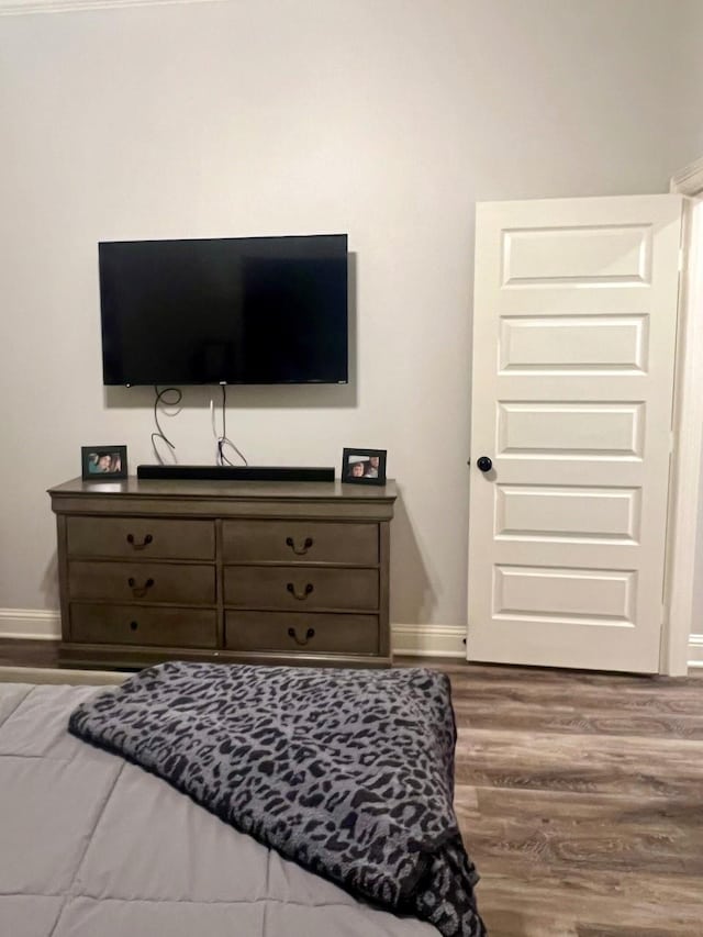 bedroom featuring baseboards and wood finished floors