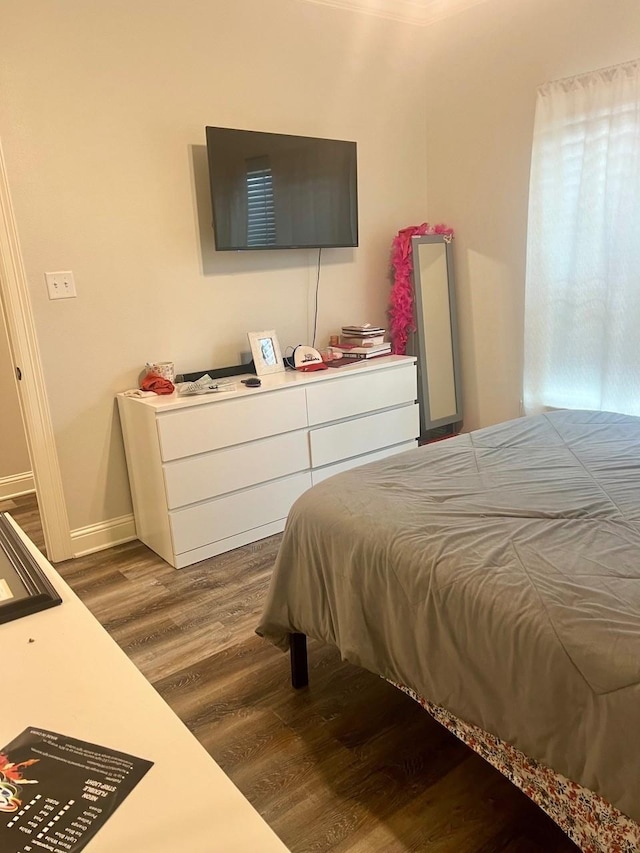 bedroom with dark wood-type flooring and baseboards