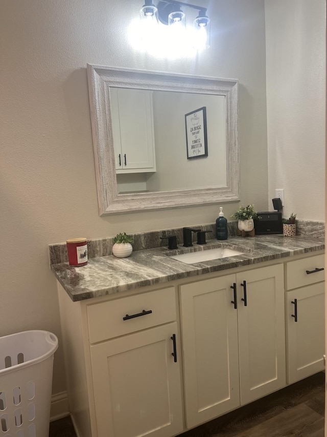 bathroom with a freestanding tub, wood finished floors, and vanity