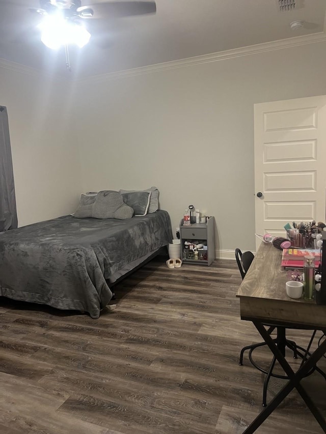 bedroom with baseboards, ornamental molding, ceiling fan, and wood finished floors