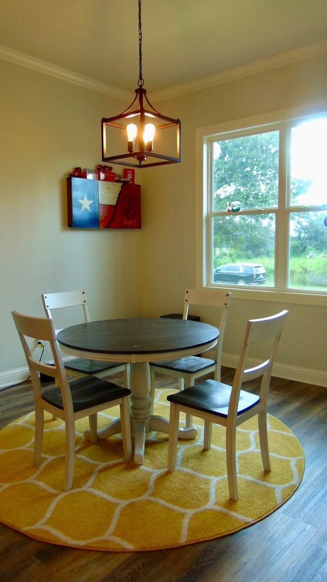 dining area with baseboards, wood finished floors, a wealth of natural light, and crown molding