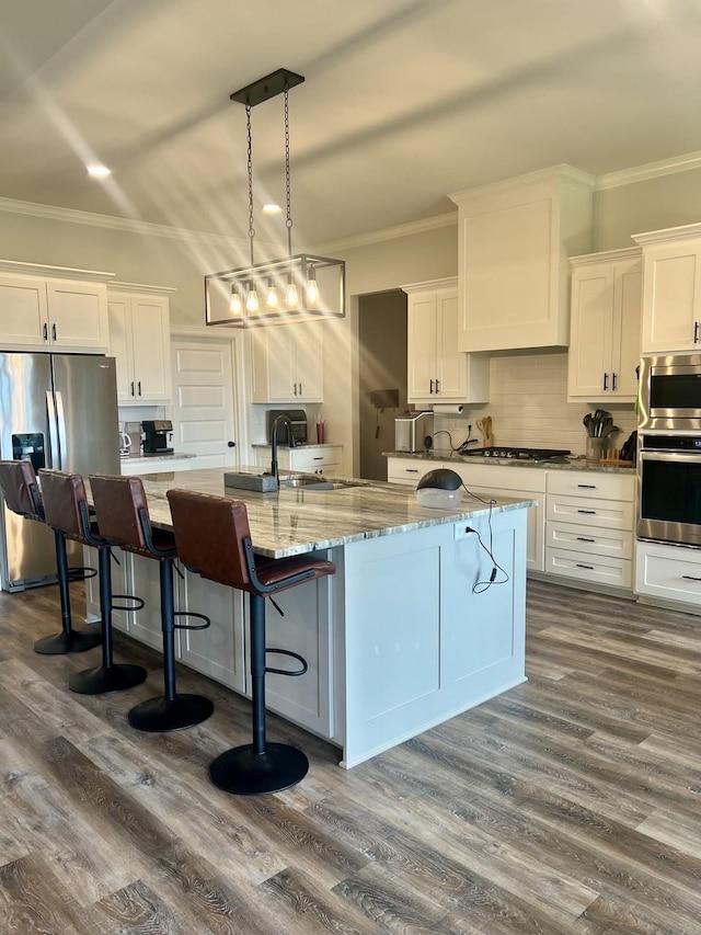 kitchen with stainless steel appliances, white cabinets, crown molding, and backsplash