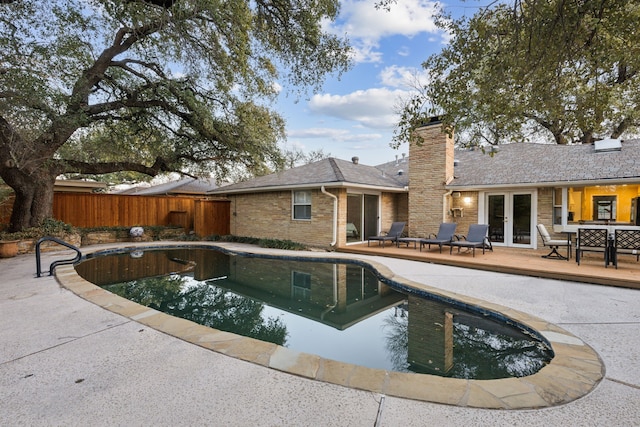 view of pool with a deck, fence, french doors, a fenced in pool, and a patio area