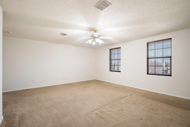 unfurnished room featuring baseboards, carpet, visible vents, and a ceiling fan