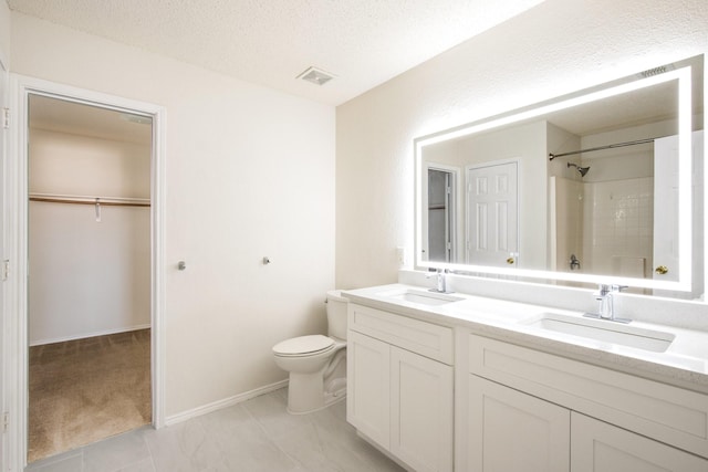 full bath with a textured ceiling, walk in shower, a sink, and toilet