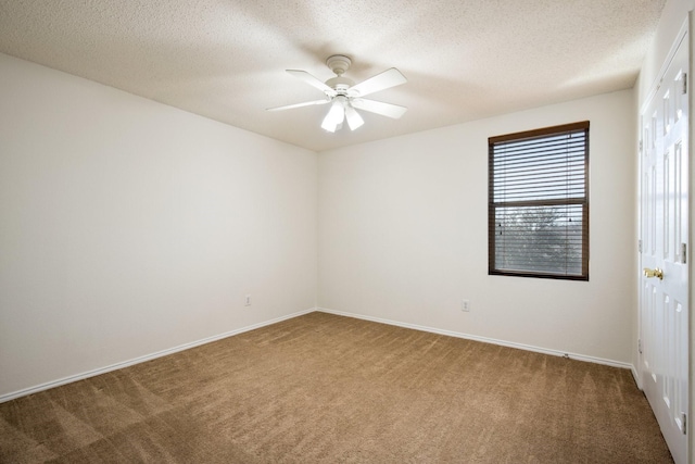 carpeted spare room with a ceiling fan, a textured ceiling, and baseboards