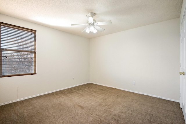 carpeted spare room with a ceiling fan, a textured ceiling, and baseboards