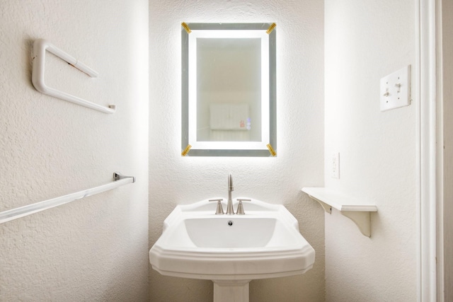 bathroom with a sink and a textured wall