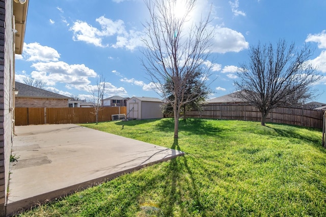 view of yard featuring an outbuilding, a storage unit, a patio area, and a fenced backyard