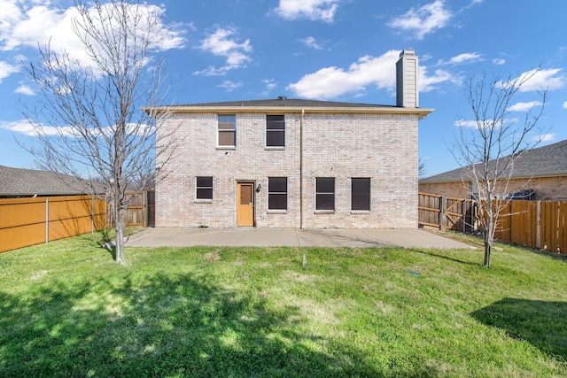 back of house with a patio area, a lawn, and brick siding