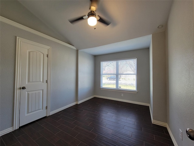 spare room featuring wood tiled floor, ceiling fan, lofted ceiling, and baseboards