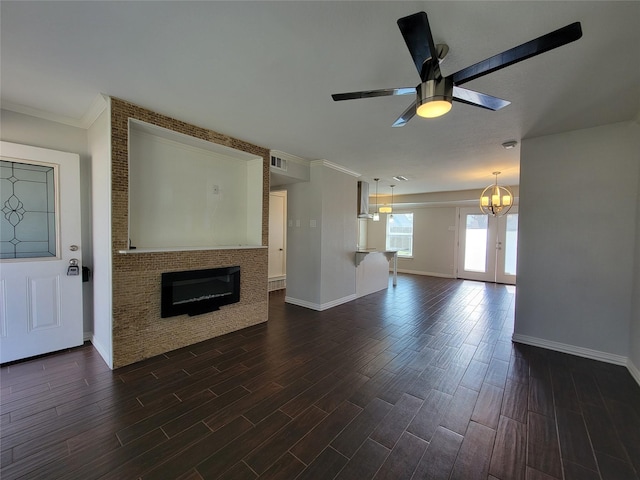 unfurnished living room with dark wood-style flooring, visible vents, baseboards, a ceiling fan, and a glass covered fireplace