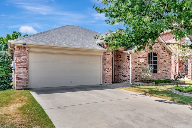 ranch-style house featuring concrete driveway, brick siding, an attached garage, and roof with shingles