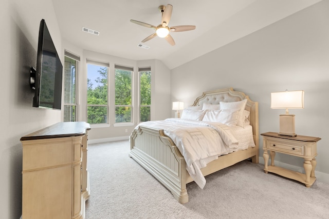 bedroom featuring baseboards, visible vents, vaulted ceiling, and light colored carpet