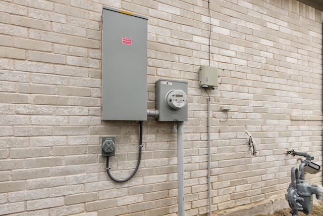 exterior details with gas meter, electric meter, and brick siding