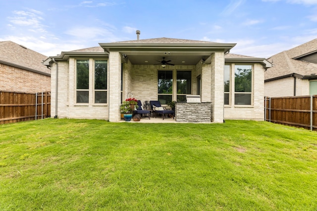 rear view of property with a lawn, a patio area, a fenced backyard, and a ceiling fan