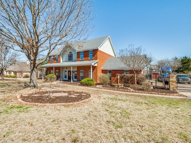 rear view of house with a yard, fence, and brick siding