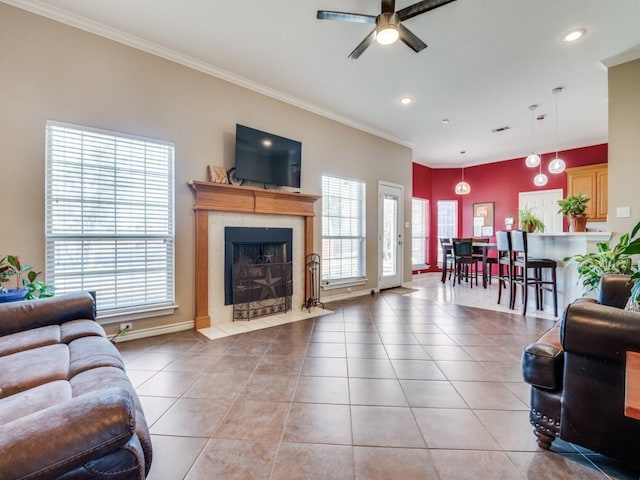 living room featuring light tile patterned floors, crown molding, and a tile fireplace