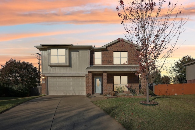 traditional home with a garage, driveway, brick siding, and a front lawn