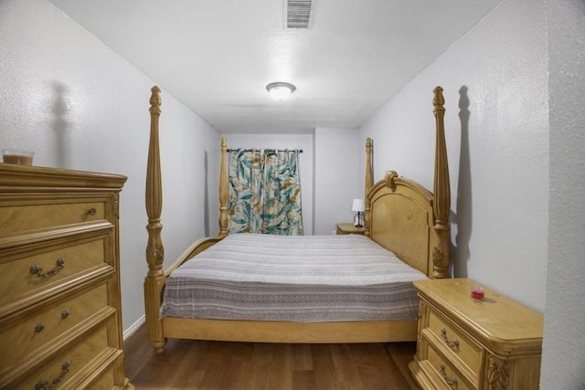 bedroom featuring visible vents and dark wood-type flooring