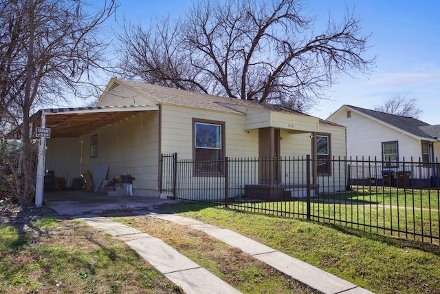 view of front of home with a fenced front yard, an attached carport, and a front yard