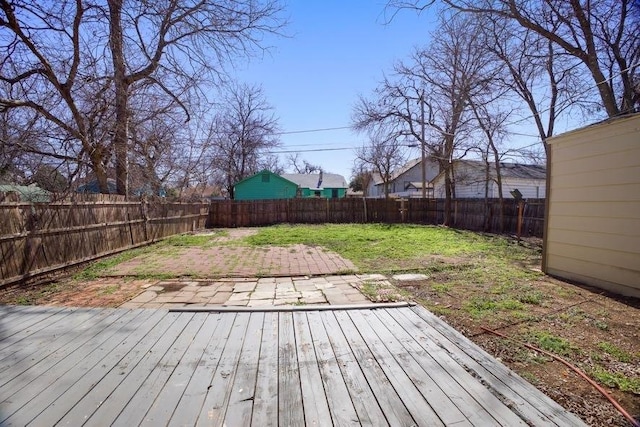 deck with a fenced backyard, a patio, and a lawn