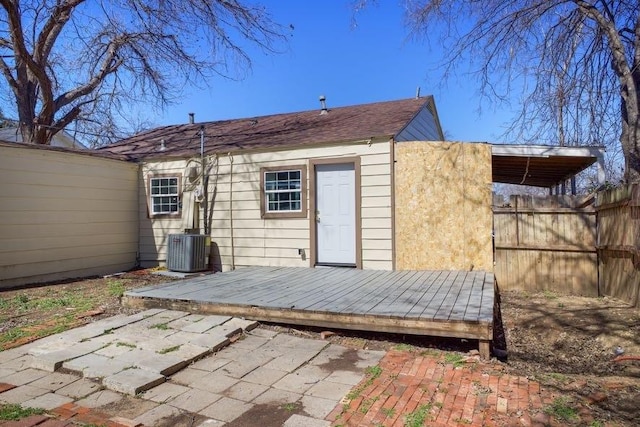 rear view of house with fence, central AC unit, and a deck