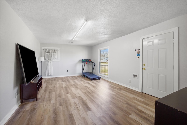 exercise area featuring light wood-style floors and baseboards