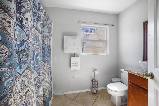 full bath featuring toilet, vanity, a shower with curtain, baseboards, and tile patterned floors