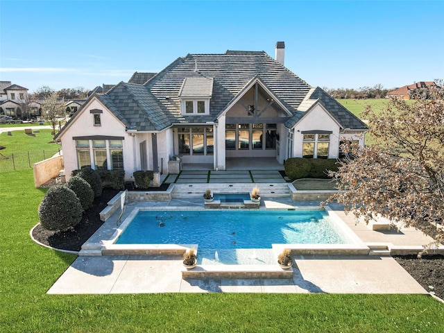 back of house with a patio, a lawn, fence, and stucco siding