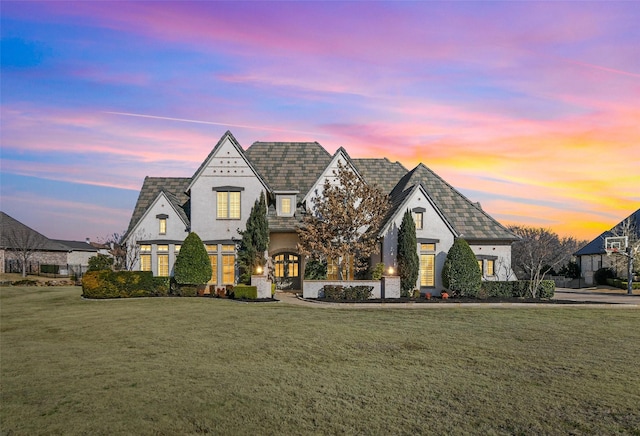 view of front of house with stucco siding and a front lawn