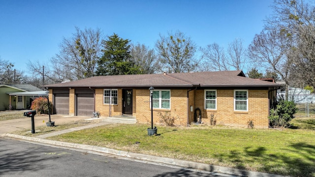 single story home featuring a garage, brick siding, and a front lawn