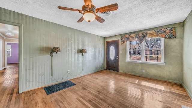 entryway featuring visible vents, a ceiling fan, a textured ceiling, hardwood / wood-style floors, and baseboards