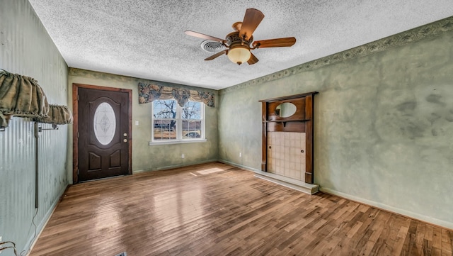 entryway featuring a textured ceiling, ceiling fan, and wood finished floors