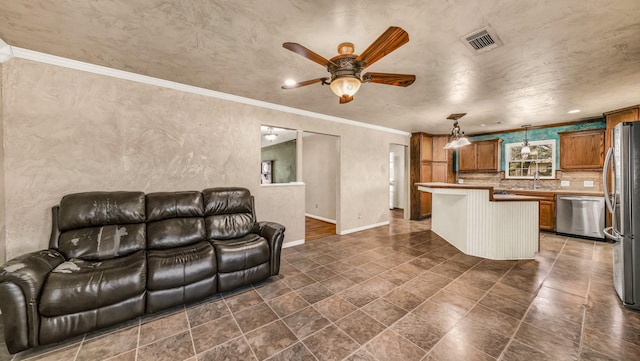 living room featuring crown molding, a ceiling fan, visible vents, and baseboards