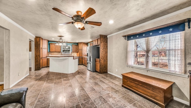 kitchen featuring a kitchen island, crown molding, baseboards, stainless steel fridge with ice dispenser, and brown cabinets