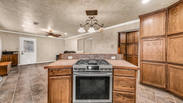 kitchen featuring visible vents, brown cabinets, gas stove, and crown molding