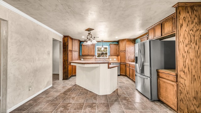 kitchen featuring brown cabinets, ornamental molding, a center island, appliances with stainless steel finishes, and light countertops