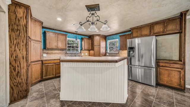 kitchen featuring visible vents, tasteful backsplash, a center island, stainless steel fridge with ice dispenser, and hanging light fixtures