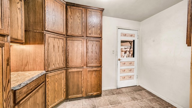 kitchen with brown cabinets, light countertops, and baseboards