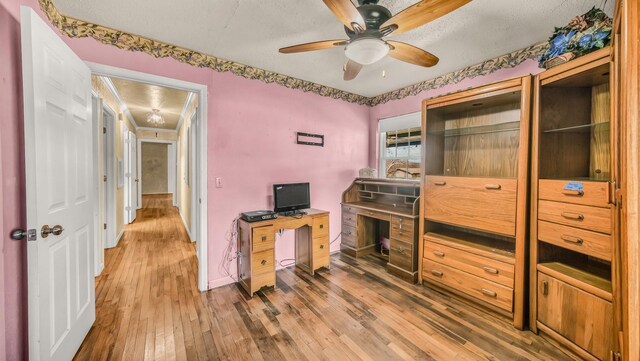 office space featuring baseboards, wood finished floors, and a ceiling fan