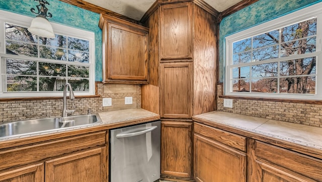 kitchen featuring backsplash, dishwasher, brown cabinets, and a sink